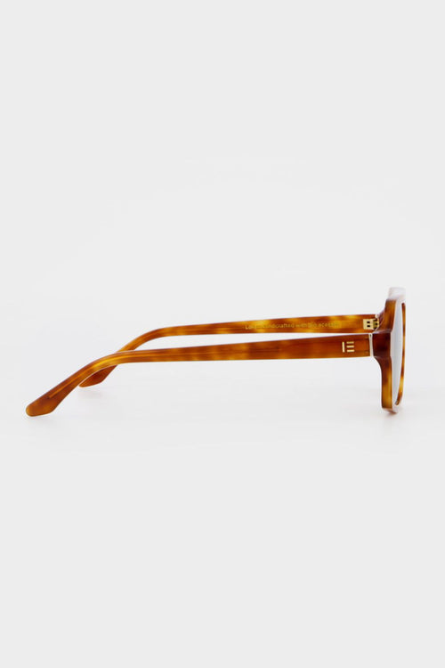Honey tortoise aviator-style sunglasses with angular frames and green-tinted lenses.