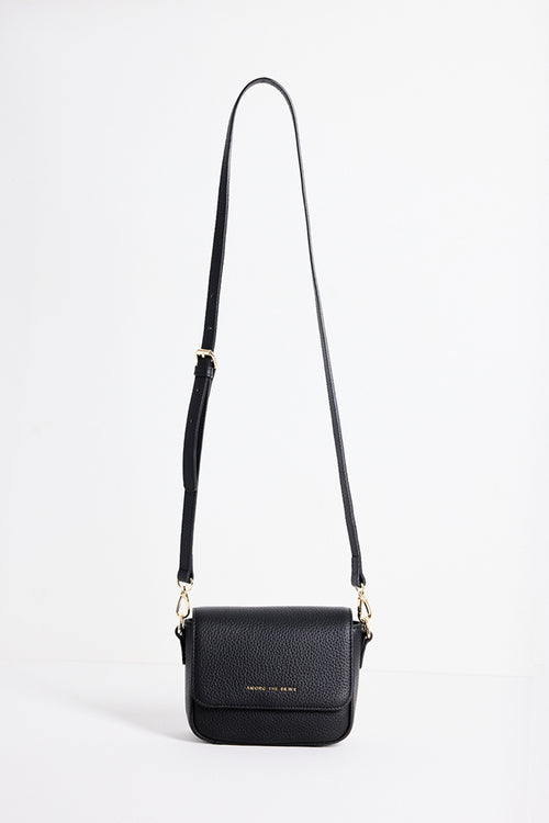 A black pebbled leather crossbody bag with a long shoulder strap and gold-tone hardware, shown against a plain white studio background.