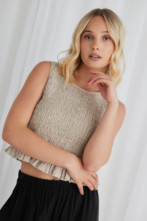 model wears a sleeveless linen top with black pants