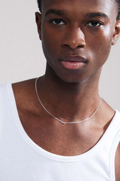 model wearing silver necklace that reads 