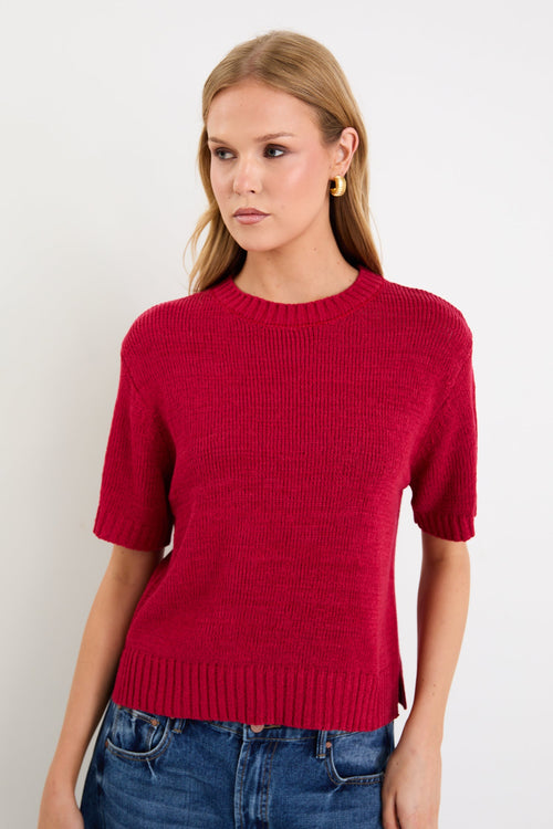 Model wearing a cherry red short sleeve knit tee with a crew neckline and side splits.