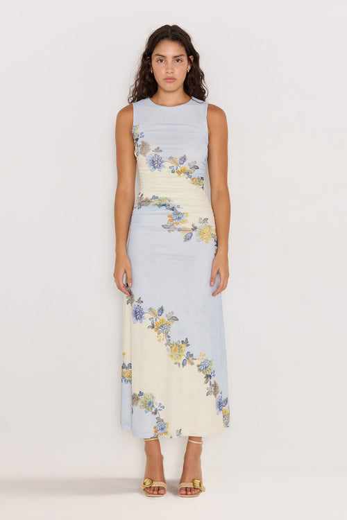 Woman wearing a light blue dress with floral patterns on a white background