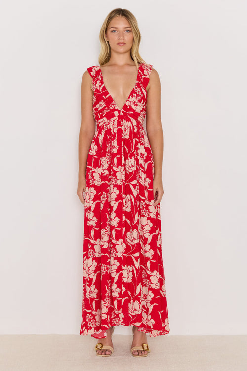 Woman wearing a red floral dress against a white background