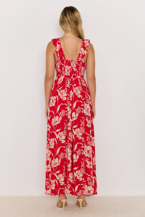 Woman wearing a red floral dress against a white background