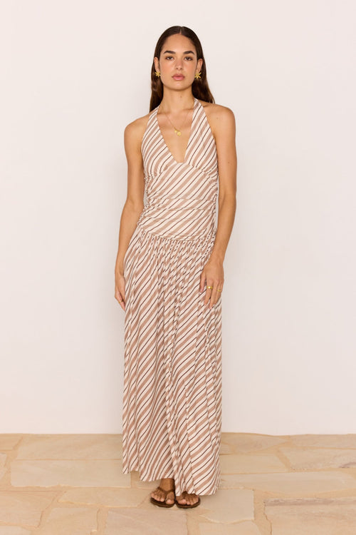 Woman wearing a patterned dress against a plain background