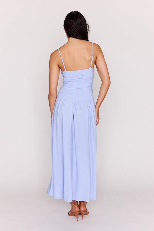 Woman wearing a light blue dress against a white background