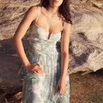 Woman in a floral dress standing on rocky terrain