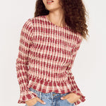 Woman wearing a red and white checkered shirt and blue jeans on a white background
