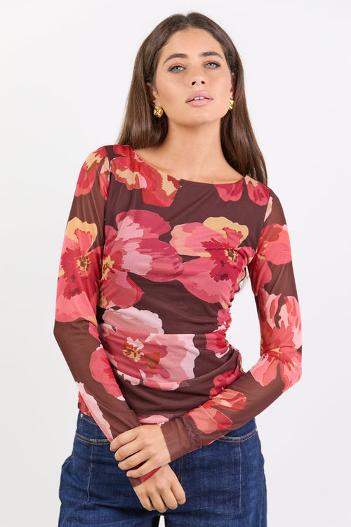Woman wearing a floral long-sleeve top with a white background