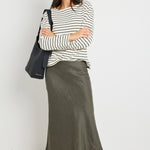 model wears a khaki linen midi skirt with waistband 