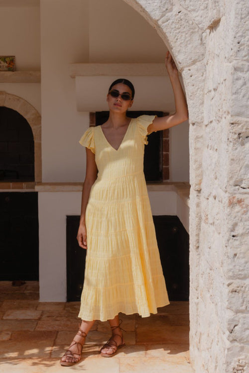 model wears a yellow flutter sleeve midi dress