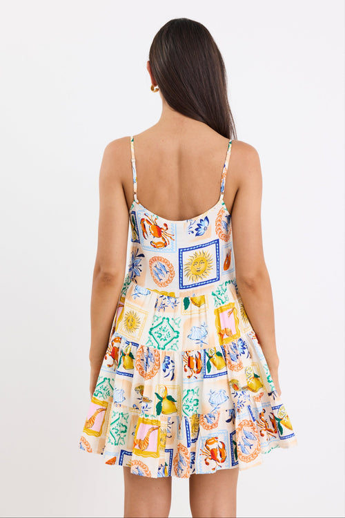 model wears a mini dress featuring a vibrant holiday print