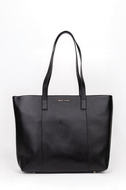 A black pebbled leather tote bag with dual shoulder straps and a small gold logo plaque on the front, photographed against a plain white background.