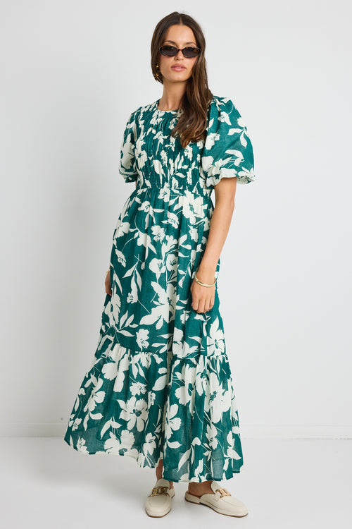 model wears a green white floral dress