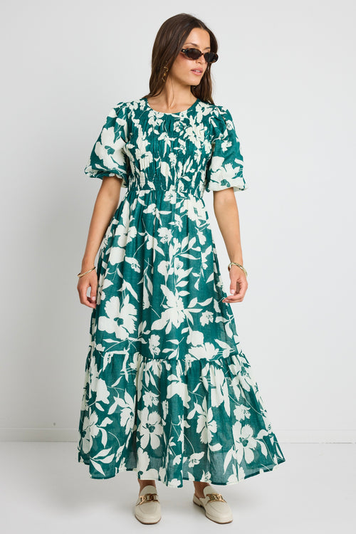 model wears a green white floral dress