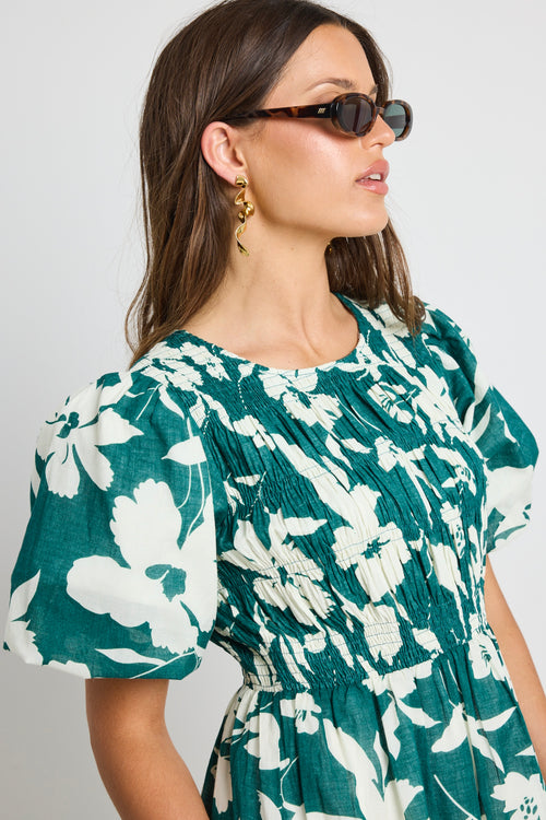 model wears a green white floral dress