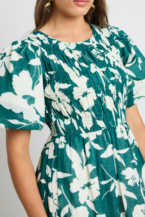 model wears a green white floral dress