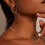 Model wears a gold hoop earring