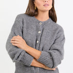 Woman wearing a grey cardigan on a white background