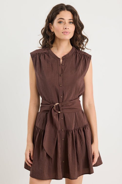 Woman wearing a brown dress with a belt on a white background