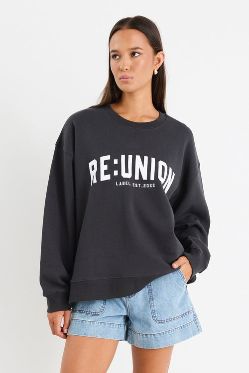 Woman wearing a charcoal grey oversized sweatshirt with 