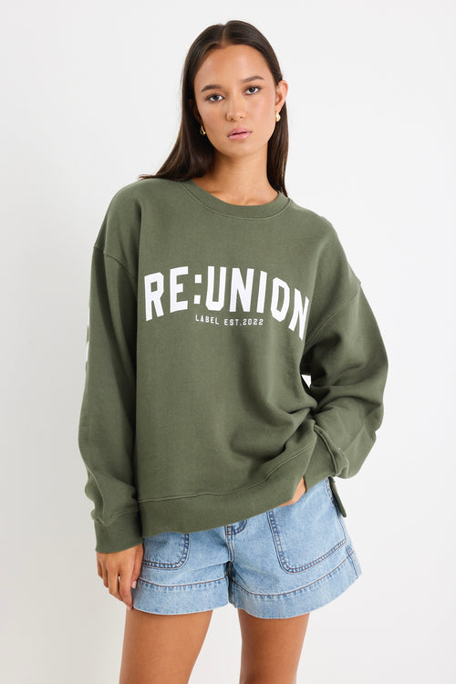 Woman wearing a khaki green oversized sweatshirt with 