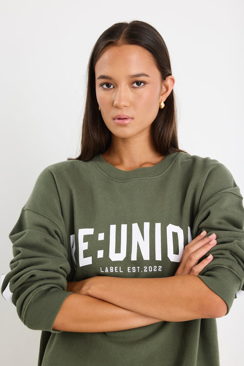 Woman wearing a khaki green oversized sweatshirt with 
