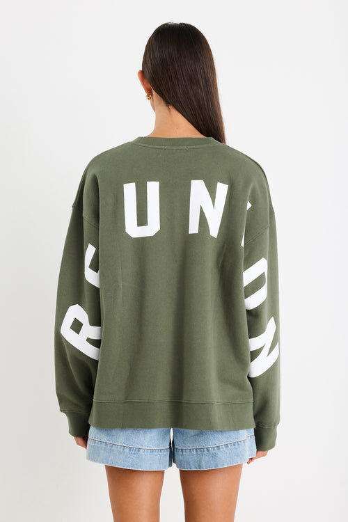 Woman wearing a khaki green oversized sweatshirt with 