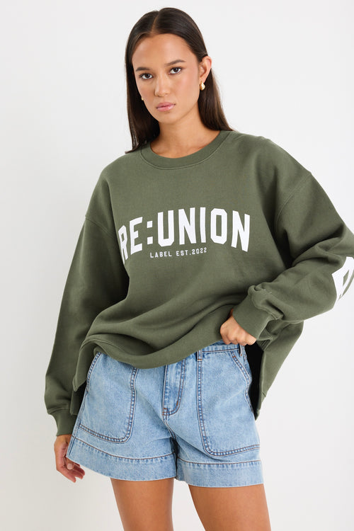 Woman wearing a khaki green oversized sweatshirt with 