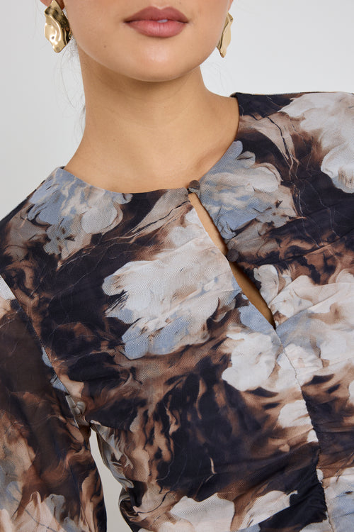 model wears a brown and blue mesh floral top with a black maxi skirt