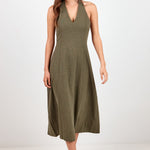 A woman modeling a sleeveless olive green midi dress with a V-neckline, standing against a plain white studio background.