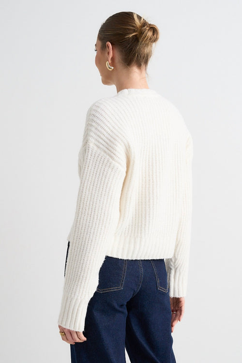 model wears a white knit jumper