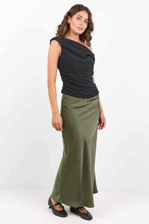 Woman wearing a black top and green skirt on a white background