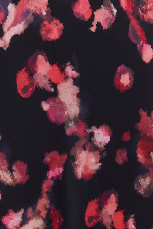 Floral patterned fabric with red, pink, and white flowers on a dark background