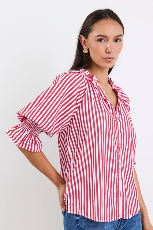 Woman wearing a red and white striped top and blue jeans