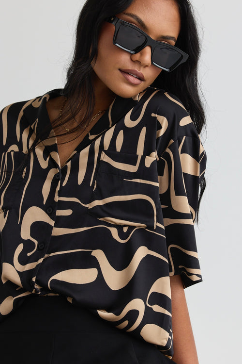 model wears a black beige pattern shirt