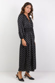 Woman wearing a black dress with white patterns on a white background