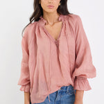 Woman wearing a pink blouse and blue jeans on a white background