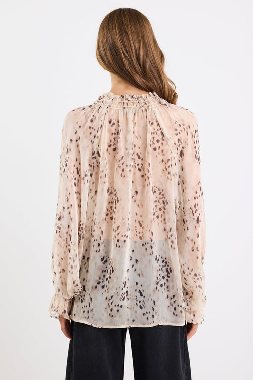 Woman wearing a floral blouse with long sleeves on a white background