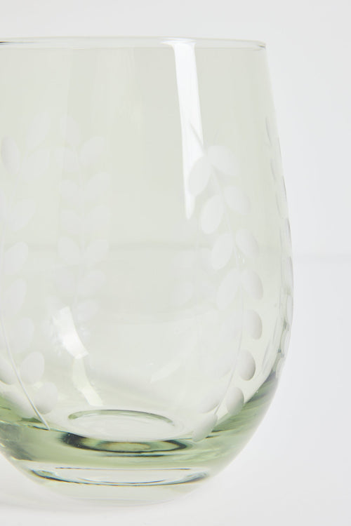 A close-up of a clear glass tumbler with a subtle etched or embossed floral pattern, set against a plain white background.