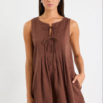 Woman wearing a brown mini dress with tie front and pleating