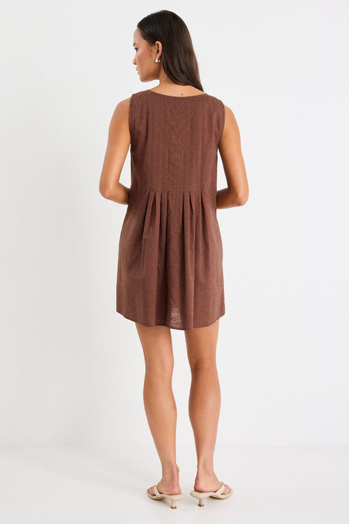 Woman wearing a brown mini dress with tie front and pleating
