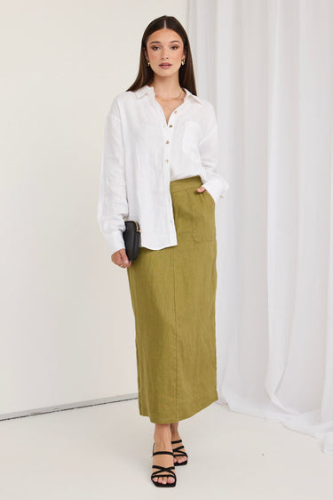 model wears a green skirt and white shirt