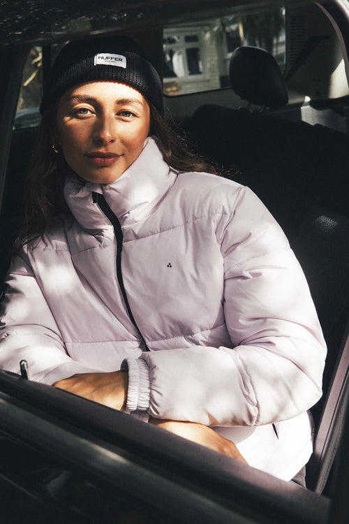 model wears a purple puffer jacket