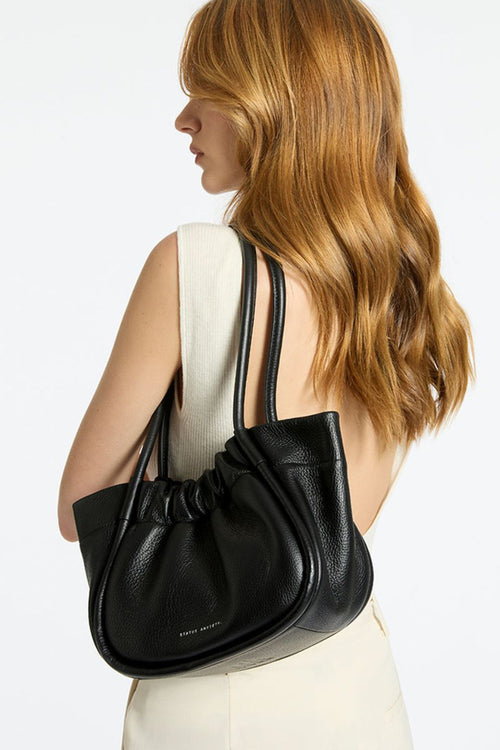 model wears a black shoulder bag