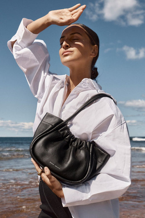 model wears a black shoulder bag