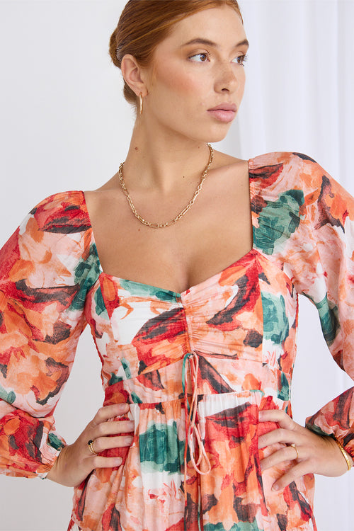 Model wears a orange floral dress