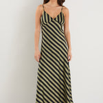 model wears a black and khaki stripe maxi dress with black heels 