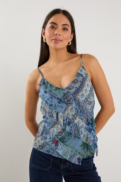 Woman wearing a strappy blue floral scarf-print top with ruffle detailing, styled with indigo jeans.