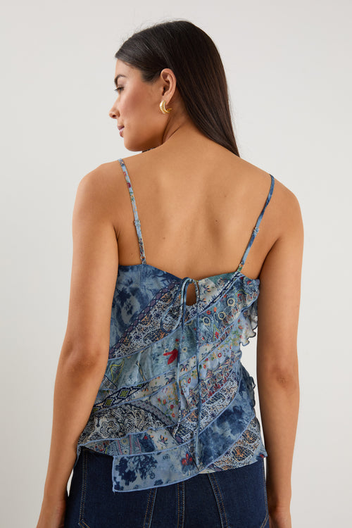 Woman wearing a strappy blue floral scarf-print top with ruffle detailing, styled with indigo jeans.